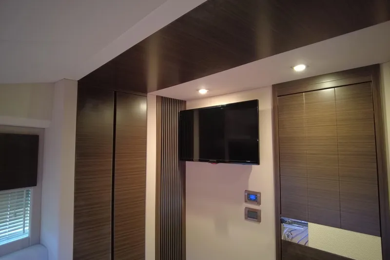 Raven Yacht Photos Pics Interior of 2014 Azimut 54 Fly Bridge yacht with modern wood paneling and mounted TV.