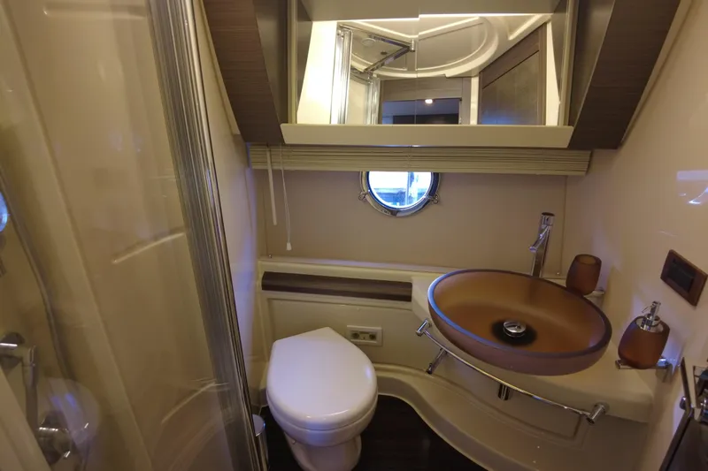 Raven Yacht Photos Pics Luxurious bathroom in 2014 Azimut 54 Fly Bridge yacht with modern fixtures and porthole window.