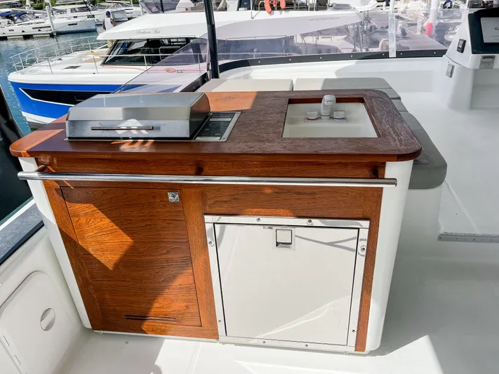 Wild Blue Yacht Photos Pics Outdoor kitchen on 2019 Fountaine Pajot MY 44 yacht with wooden cabinetry and grill.