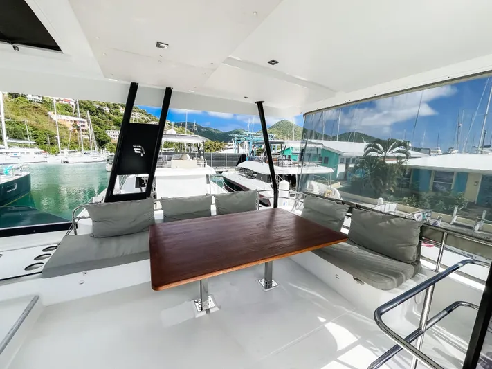 Wild Blue Yacht Photos Pics 2019 Fountaine Pajot MY 44 yacht with spacious outdoor seating and table, docked at marina.