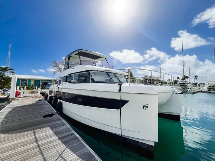 Wild Blue Yacht Photos Pics 2019 Fountaine Pajot MY 44 yacht docked under a bright blue sky.