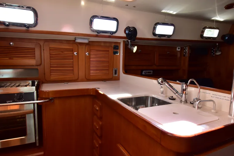 Jellyfish Problems Yacht Photos Pics Interior of 2008 Caliber 40 LRC SE yacht kitchen with wood cabinetry and stainless steel sink.