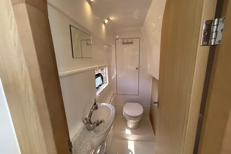  Yacht Photos Pics Modern bathroom interior of 2020 Aquila 36 Sport yacht, featuring sink, toilet, and mirror.