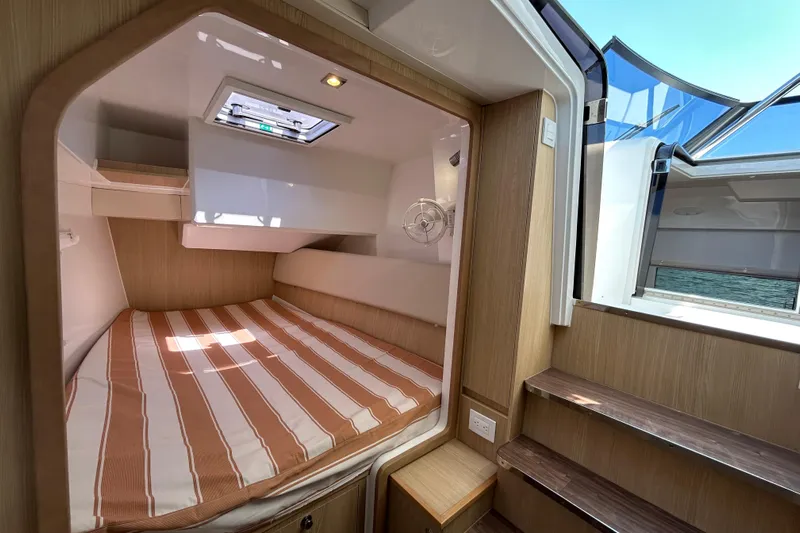  Yacht Photos Pics Cozy cabin interior of 2020 Aquila 36 Sport yacht with striped bedding and natural light.