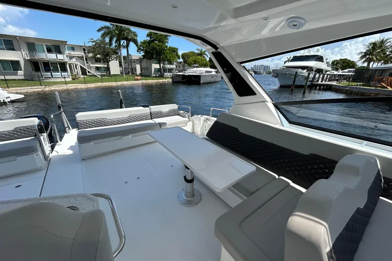  Yacht Photos Pics Aquila 36 Sport 2020 boat interior with seating and table, docked near waterfront homes.