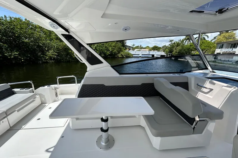  Yacht Photos Pics Aquila 36 Sport 2020 boat interior with seating and table, near a scenic waterway.