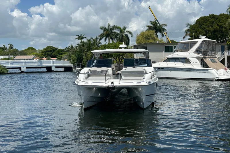  Yacht Photos Pics 2020 Aquila 36 Sport catamaran docked on a sunny day with palm trees in the background.
