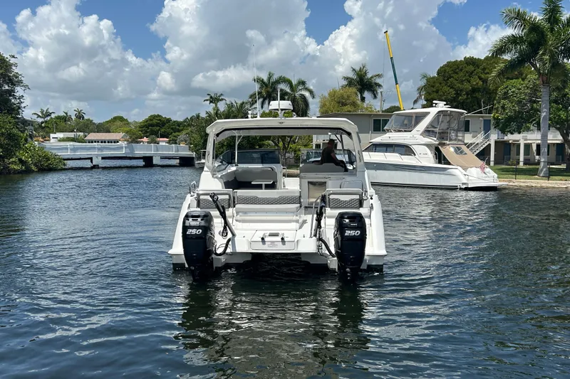  Yacht Photos Pics 2020 Aquila 36 Sport boat on a scenic waterway with palm trees and blue sky.