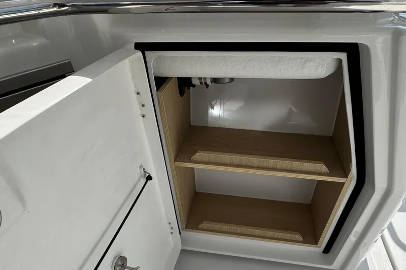  Yacht Photos Pics Open storage compartment on 2020 Aquila 36 Sport boat, featuring wooden shelves.