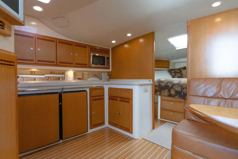 Tomahawk Yacht Photos Pics 2008 Cabo 40 Express yacht interior with kitchen, wood cabinetry, and cozy seating area.