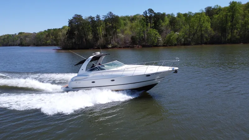  Yacht Photos Pics 2004 Cruisers Yachts 370 Express speeding on a scenic lake.