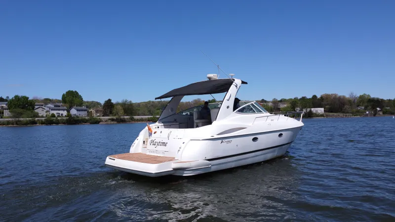  Yacht Photos Pics 2004 Cruisers Yachts 370 Express on a serene lake under clear blue skies.