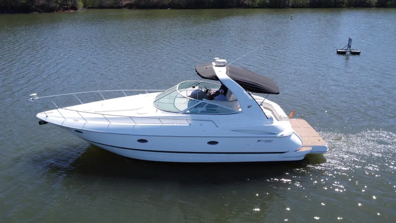  Yacht Photos Pics 2004 Cruisers Yachts 370 Express on calm water, side view with black canopy.