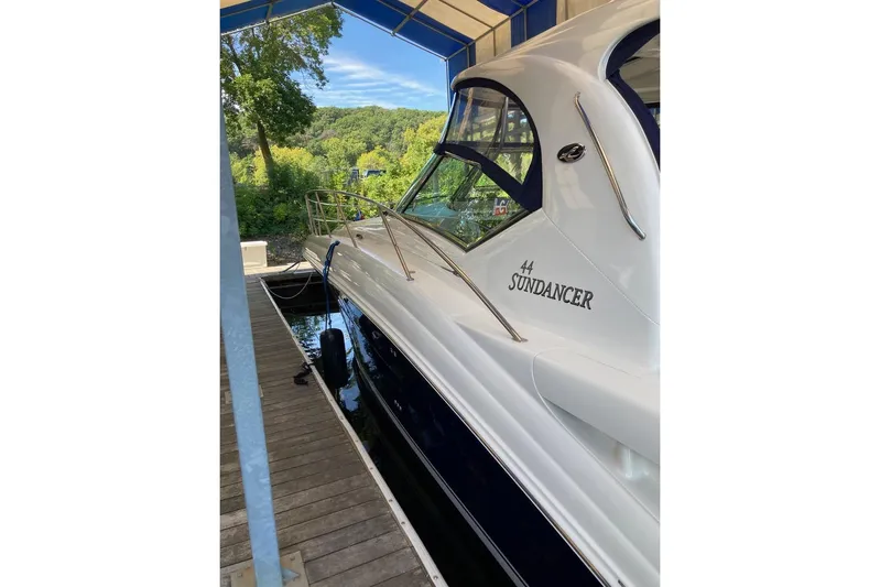 Co Motion Yacht Photos Pics 2008 Sea Ray 44 Sundancer yacht docked under a canopy, surrounded by lush greenery.