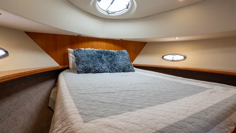  Yacht Photos Pics 2002 Silverton 41 Sport Bridge cabin with bed, portholes, and overhead hatch.