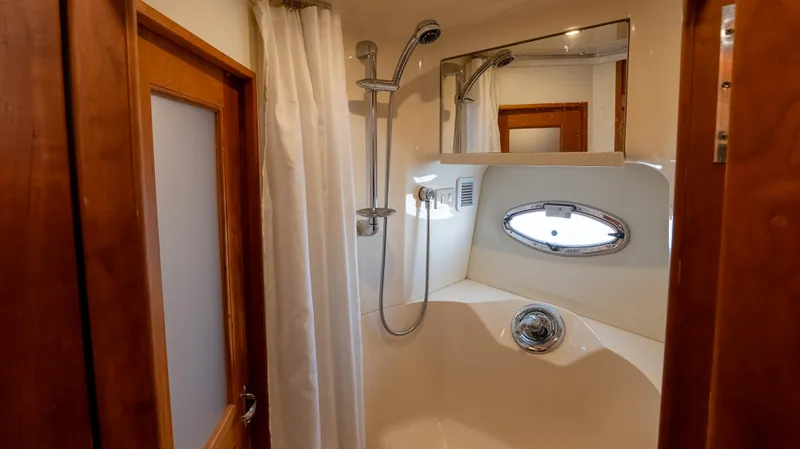  Yacht Photos Pics Shower area in 2002 Silverton 41 Sport Bridge yacht with porthole and curtain.