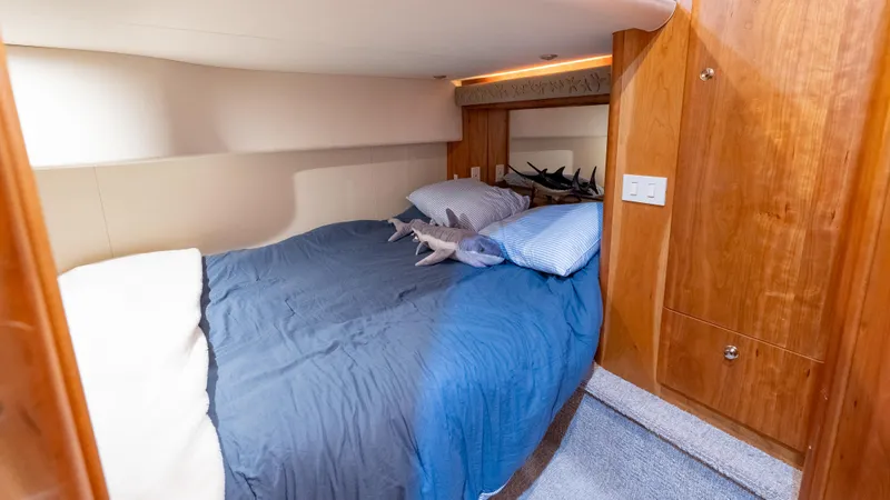  Yacht Photos Pics 2002 Silverton 41 Sport Bridge cabin with cozy bed and wooden cabinetry.