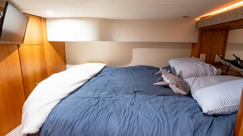  Yacht Photos Pics Cozy bedroom in 2002 Silverton 41 Sport Bridge yacht with blue bedding and TV.