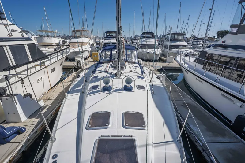 "champagne" Yacht Photos Pics Jeanneau Sun Odyssey 45.2 sailboat, 2003 model, docked in a marina surrounded by other boats.