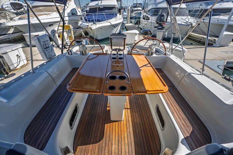 "champagne" Yacht Photos Pics 2003 Jeanneau Sun Odyssey 45.2 sailboat cockpit with wooden table and steering wheel.