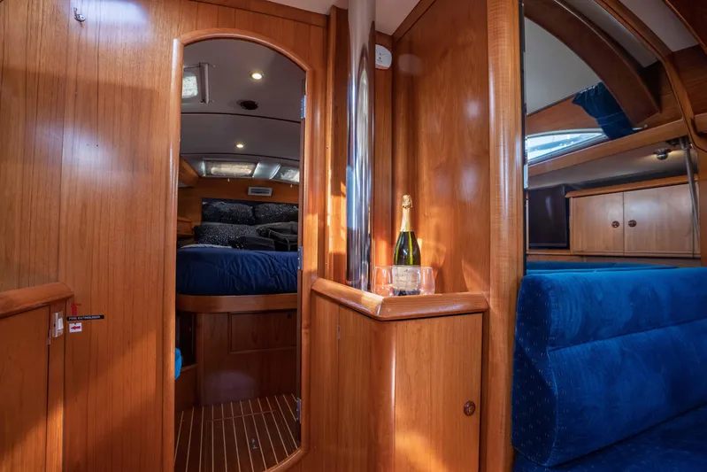 "champagne" Yacht Photos Pics Interior of 2003 Jeanneau Sun Odyssey 45.2 yacht with wood finish and blue seating.