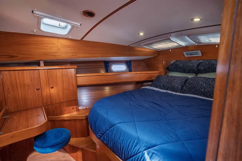 "champagne" Yacht Photos Pics Luxurious cabin interior of 2003 Jeanneau Sun Odyssey 45.2 yacht with wood finish and cozy bedding.