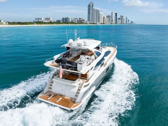 Deep Blue Yacht Photos Pics Luxurious 2018 Azimut Flybridge yacht cruising near a city skyline on a sunny day.