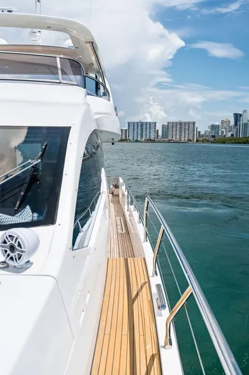 Deep Blue Yacht Photos Pics 2018 Azimut Flybridge yacht cruising near city skyline under blue sky.