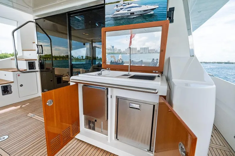 Deep Blue Yacht Photos Pics 2018 Azimut Flybridge yacht interior with kitchenette, featuring wood cabinetry and ocean view.