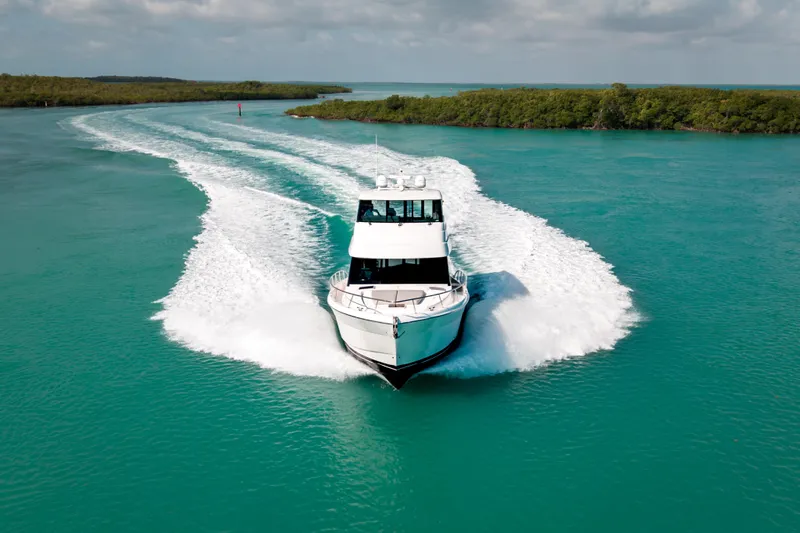 Godspeed Yacht Photos Pics 2024 Maritimo M55 yacht cruising on turquoise waters, leaving a wake behind.