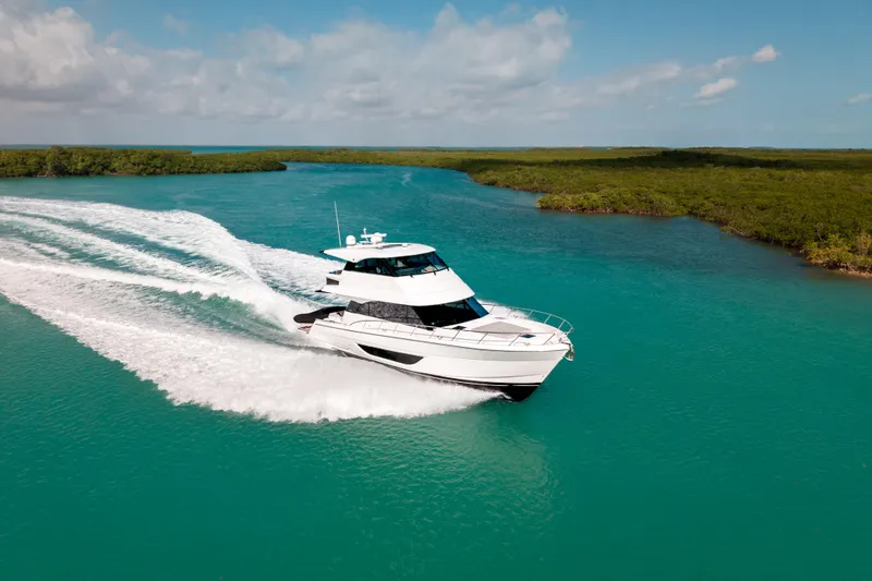 Godspeed Yacht Photos Pics 2024 Maritimo M55 yacht cruising on turquoise waters under a clear sky.