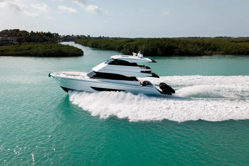 Godspeed Yacht Photos Pics 2024 Maritimo M55 yacht cruising on turquoise water, surrounded by lush greenery.