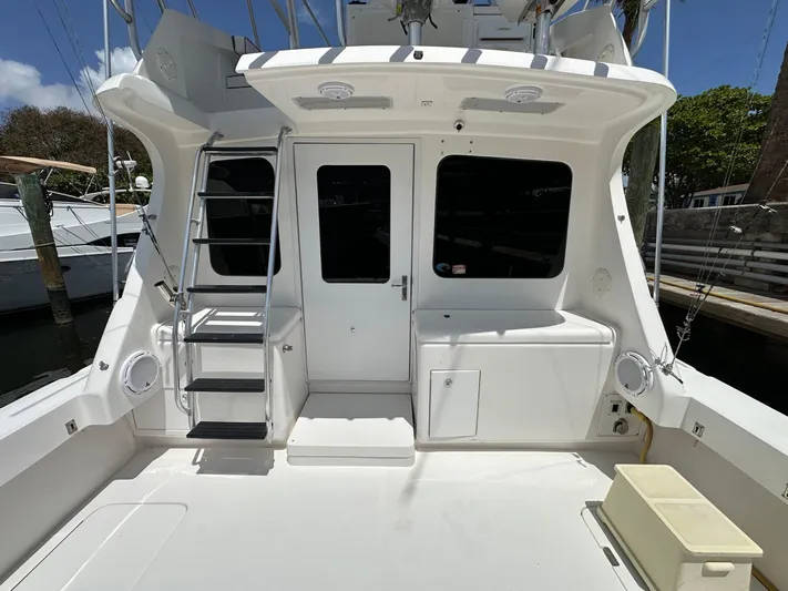  Yacht Photos Pics 2003 Luhrs 40 Convertible yacht stern with ladder and door, docked in marina.