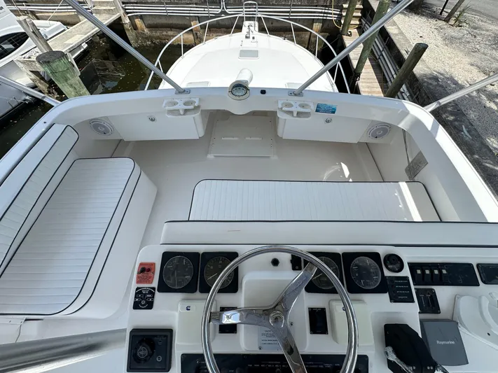  Yacht Photos Pics 2003 Luhrs 40 Convertible boat cockpit with steering wheel and seating area.
