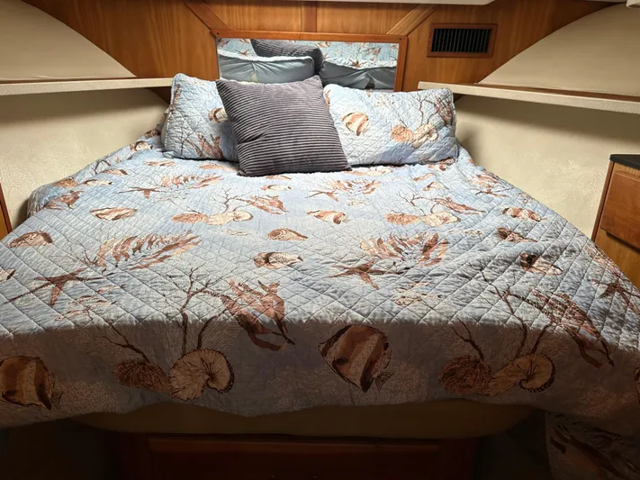  Yacht Photos Pics 2003 Luhrs 40 Convertible cabin with a cozy, nautical-themed bedspread and pillows.