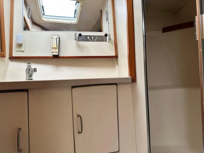  Yacht Photos Pics 2003 Luhrs 40 Convertible yacht bathroom with mirror, sink, and storage cabinets.