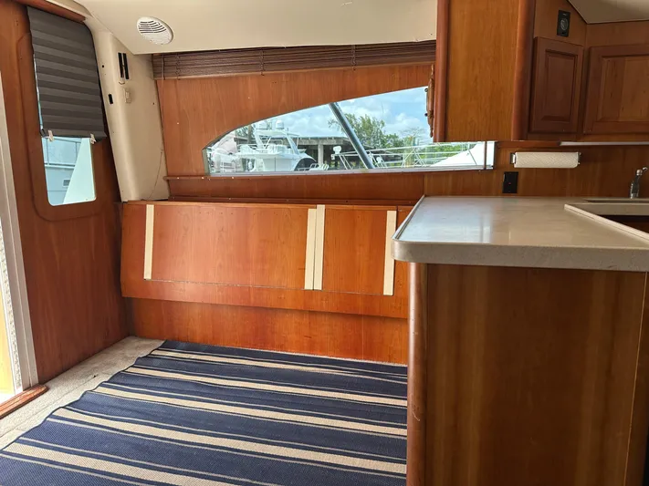  Yacht Photos Pics Interior of 2003 Luhrs 40 Convertible yacht with wood paneling and striped rug.