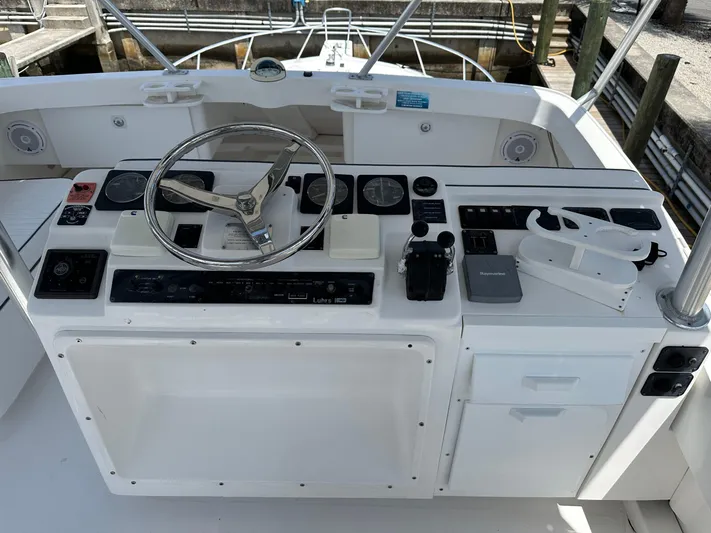  Yacht Photos Pics 2003 Luhrs 40 Convertible boat helm with steering wheel and control panel.