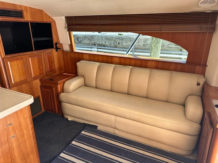  Yacht Photos Pics 2003 Luhrs 40 Convertible yacht interior with beige sofa and wooden cabinetry.