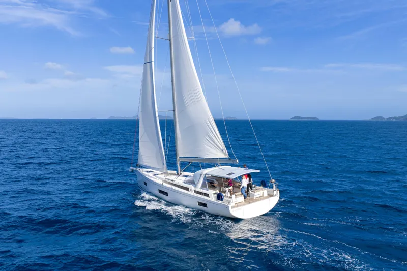 Heartbeat Yacht Photos Pics 2024 Beneteau Oceanis Yacht 54 sailing on open sea under clear blue sky.
