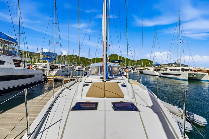 Heartbeat Yacht Photos Pics 2024 Beneteau Oceanis Yacht 54 docked in a marina, surrounded by sailboats.