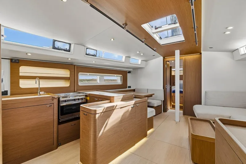 Heartbeat Yacht Photos Pics Luxurious interior of 2024 Beneteau Oceanis Yacht 54 with modern kitchen and seating area.