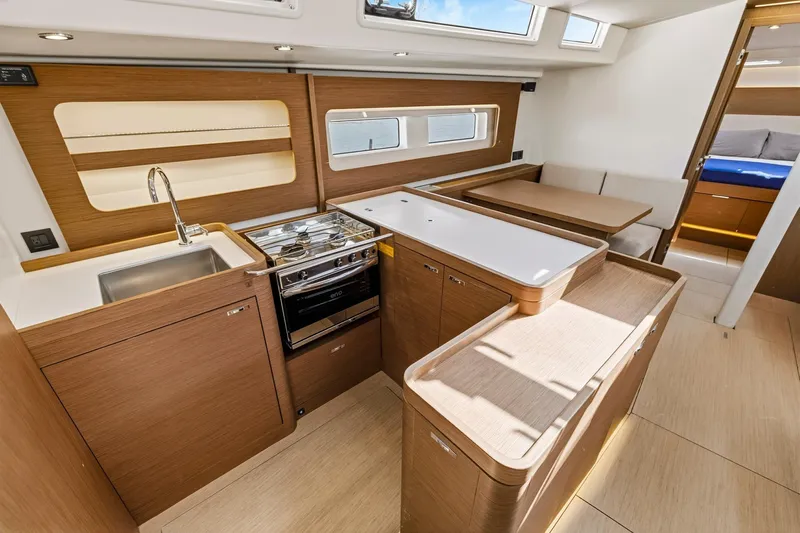 Heartbeat Yacht Photos Pics Luxurious interior of 2024 Beneteau Oceanis Yacht 54, featuring modern kitchen and dining area.