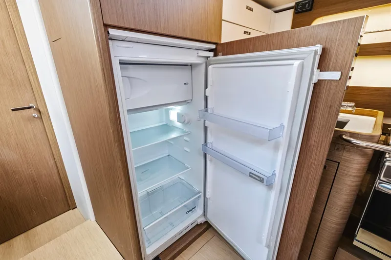 Heartbeat Yacht Photos Pics Open refrigerator in 2024 Beneteau Oceanis Yacht 54, showcasing spacious interior and modern design.
