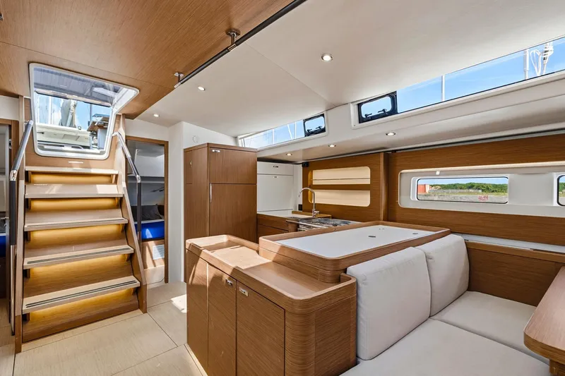 Heartbeat Yacht Photos Pics Luxurious interior of 2024 Beneteau Oceanis Yacht 54 with modern wood finish and ample natural light.