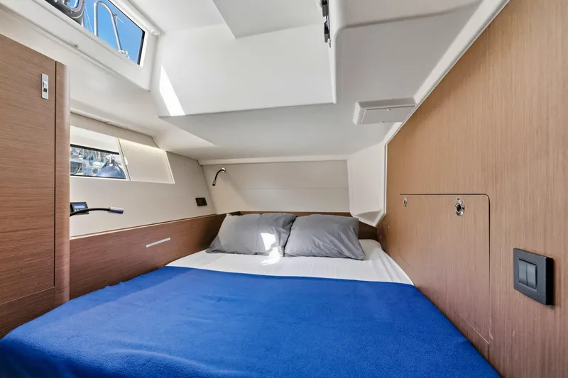 Heartbeat Yacht Photos Pics Luxurious cabin interior of 2024 Beneteau Oceanis Yacht 54 with cozy bedding.