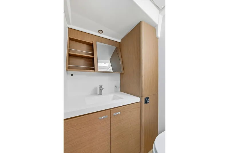 Heartbeat Yacht Photos Pics 2024 Beneteau Oceanis Yacht 54 bathroom with modern sink and wooden cabinetry.