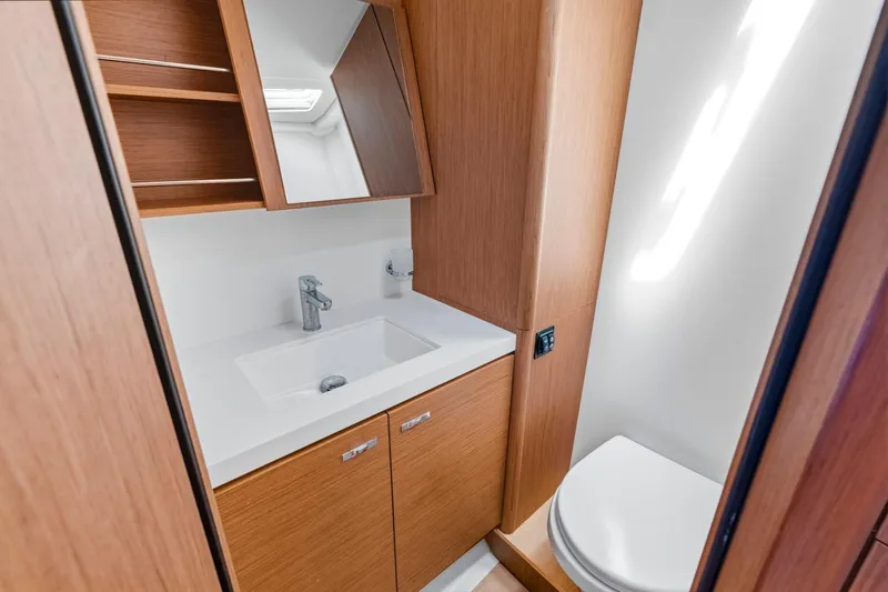 Heartbeat Yacht Photos Pics Luxurious bathroom in 2024 Beneteau Oceanis Yacht 54, featuring modern sink and wooden cabinetry.