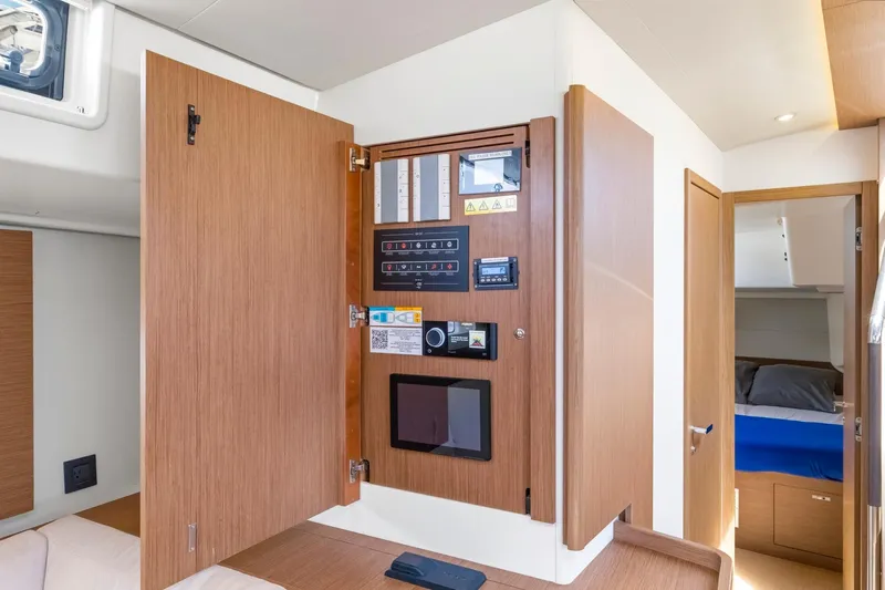 Heartbeat Yacht Photos Pics 2024 Beneteau Oceanis Yacht 54 interior control panel with open wooden cabinet.