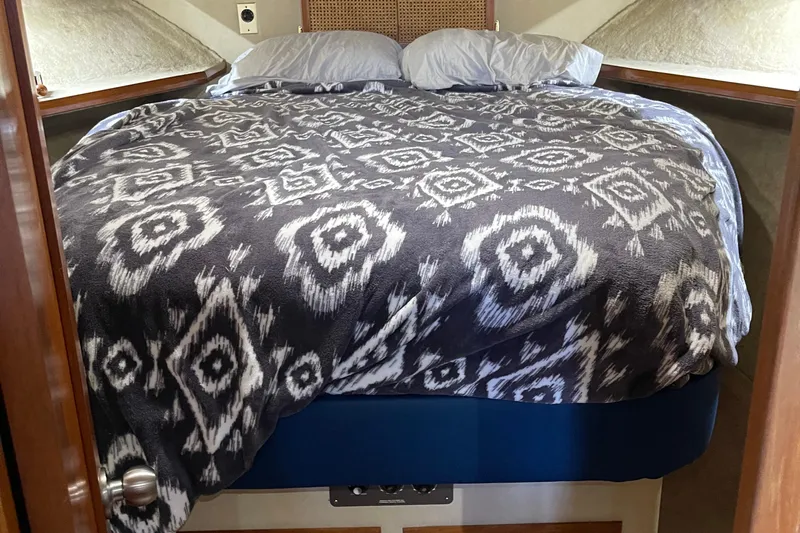  Yacht Photos Pics Cozy cabin bed in 1988 Chris-Craft 392 Sport Fish boat with patterned blanket.